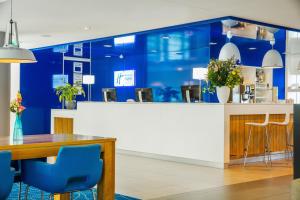 a living room filled with furniture and a blue wall at Holiday Inn Express Rotterdam - Central Station, an IHG Hotel in Rotterdam