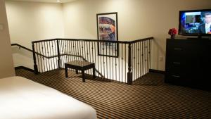 a room with a bed and a television and a chair at Holiday Inn Express Hollywood Walk of Fame by IHG in Los Angeles