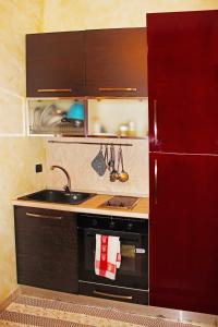 a kitchen with a sink and a red refrigerator at Le Sorelle in Lecce