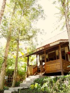 a wooden house with a porch in the woods at Green Vanilla Bungalow in Sidemen