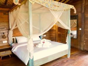 a bedroom with a bed with a canopy at Green Vanilla Bungalow in Sidemen