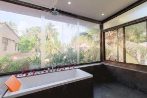 a bath tub in a room with a large window at Villa Calangute Phase 1 in Calangute