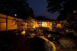 和美再美 石動 柏屋 Wabisabi Isurugi Kashiwaya في Oyabe: منزل به أضواء في الفناء ليلا