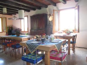 una cocina con mesas y sillas de madera en una habitación en Fara1911 en Fonte