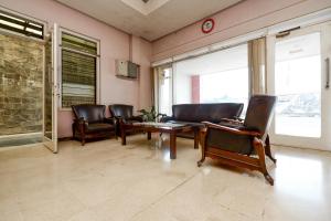 a living room with leather chairs and a table at OYO 1843 Cahya Nirwana in Purwokerto
