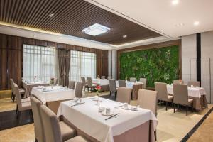 a dining room with white tables and chairs at Holiday Inn Express Baoji City Centre by IHG in Baoji