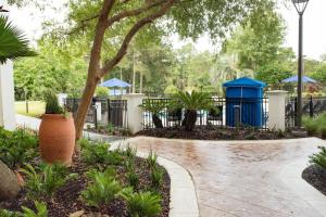 a garden with a fence and a blue shed at Holiday Inn Express Pascagoula-Moss Point, an IHG Hotel in Moss Point