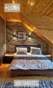 a bed in a room with a stone wall at Buta Hotel Lerik in Lerik