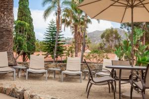 un grupo de sillas y mesas y una sombrilla en Catalina Canyon Inn, en Avalon