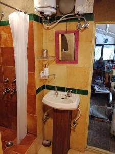 a bathroom with a sink and a mirror at The Mirage Andretta in Pālampur