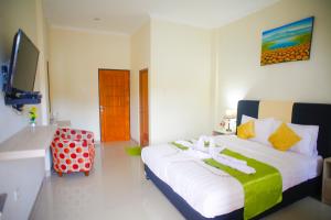 a hotel room with a bed and a tv at Pavilla Labuan Bajo in Labuan Bajo