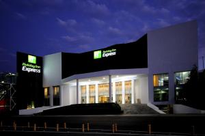 a large building with a sign on it at night at Holiday Inn Express Toluca, an IHG Hotel in Toluca