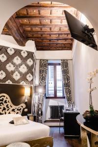 a bedroom with a bed and a desk and a window at Locanda Del Sole-Roma in Rome