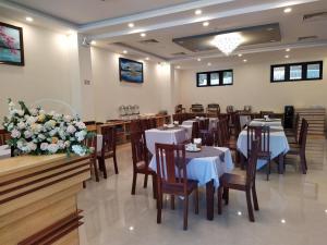 a restaurant with tables and chairs and flowers at Lan Anh Hotel in Da Lat