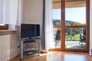 Televízia a/alebo spoločenská miestnosť v ubytovaní Aba Apartamenty
