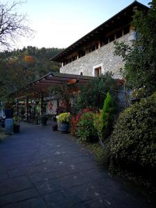 un edificio de piedra con pérgola de madera y plantas en Larramendi Torrea, en Azcoitia