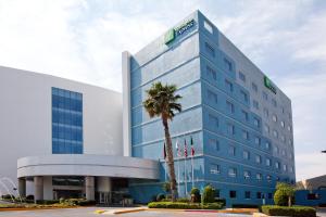 un edificio con una palmera delante de él en Holiday Inn Express San Luis Potosí, an IHG Hotel, en San Luis Potosí