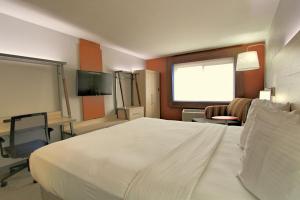 um quarto de hotel com uma grande cama branca e uma janela em Holiday Inn Express Sedona - Oak Creek, an IHG Hotel em Sedona