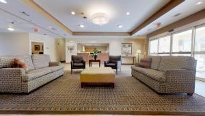 スライデルにあるCandlewood Suites Slidell Northshore, an IHG Hotelのソファとテーブル付きの広いリビングルーム