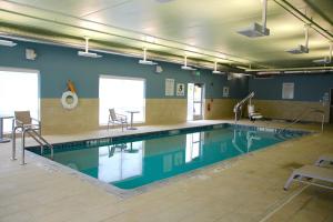 a large swimming pool in a gym with at Holiday Inn Express & Suites Oswego, an IHG Hotel in Oswego