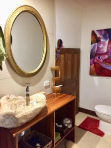 uma casa de banho com um lavatório e um espelho na parede em Bali with a twist em Nelson