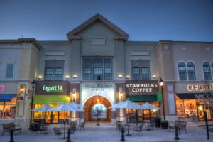 a building with tables and umbrellas in front of it at Holiday Inn Express & Suites Toledo South - Perrysburg by IHG in Perrysburg Heights