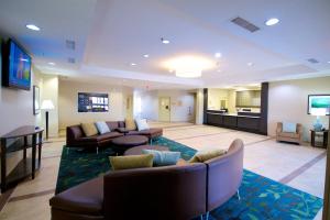 a hotel lobby with couches and a flat screen tv at Candlewood Suites Kenedy, an IHG Hotel in Kenedy