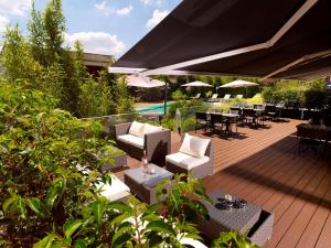 a wooden deck with tables and chairs and an umbrella at Holiday Inn Express Toulouse Airport, an IHG Hotel in Blagnac
