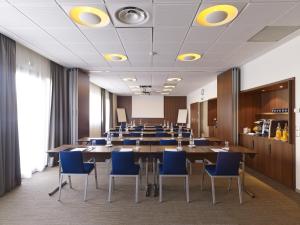 a conference room with a long table and blue chairs at Holiday Inn Express Toulouse Airport, an IHG Hotel in Blagnac