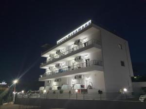 a large white building with lights on it at night at Hotel Mira Mare in Ksamil