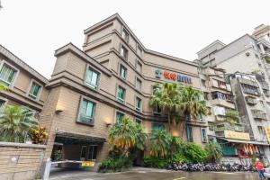 un edificio con palme di fronte di Love Tree Motel a Taipei