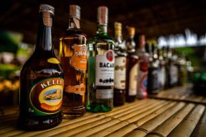 a row of bottles of alcohol sitting on a wooden table at Ao Nang Bamboo Resort in Ao Nang Beach