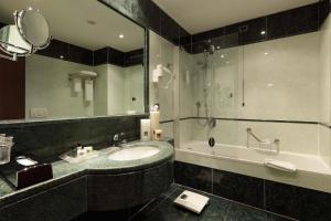 a bathroom with a sink and a tub and a mirror at Holiday Inn Turin Corso Francia by IHG in Turin