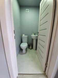 La salle de bains est pourvue de toilettes et d'un lavabo. dans l'établissement Отель "Grey house", à Touapsé