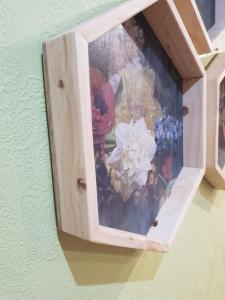 una foto de flores en una caja de madera en una pared en Rozenhof Guest Cottages, en George