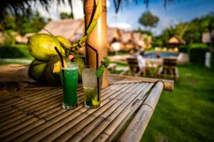 dos bebidas están sentadas en una mesa de madera en AoNang Bamboo Pool Resort, en Ao Nang Beach