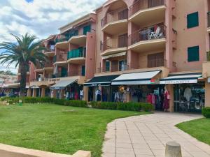 un edificio de apartamentos rosa con una tienda de ropa enfrente en Les Marines d'Agay Studio climatisé en Saint-Raphaël