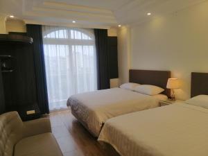 a hotel room with two beds and a window at Sao Mai Cosy Nest-Noi Bai Airport in Thach Loi
