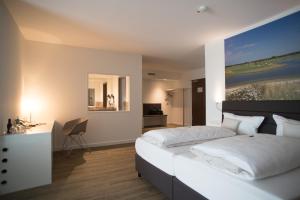een slaapkamer met een groot wit bed en een bureau bij Hotel absolute in Gernsheim