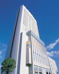 a tall white building with a tree in front of it at ANA Crowne Plaza Hotel Grand Court Nagoya, an IHG Hotel in Nagoya