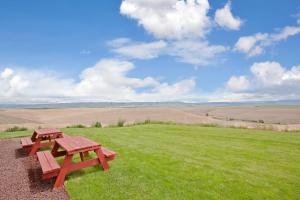 una mesa de picnic en una colina con césped y un campo en Holiday Inn Express Pendleton by IHG, en Pendleton