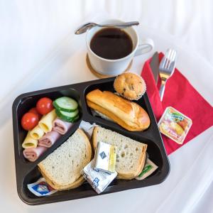 a black tray with sandwiches and a cup of coffee at AirPark Balice in Balice