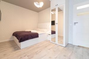 a bedroom with a bed and a mirror at Apartament Pod Czantorią z tarasem - Dream Apart in Ustroń