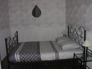 a bedroom with a bed with a wrought iron frame at Hortensia du Der Familial in Montier-en-Der