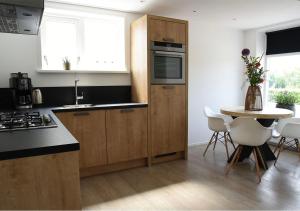 a kitchen with wooden cabinets and a table and a counter top at Sfeervol vakantiehuis in Holwerd in Holwerd