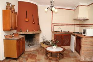 a kitchen with a fireplace and a table in a room at Chacón in Prado del Rey
