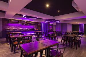 un ristorante con tavoli e sedie in una stanza con illuminazione viola di Seven Fukun Hotel a Jiaoxi