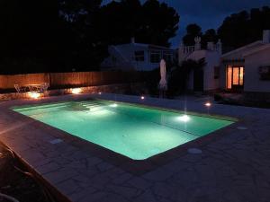 een zwembad in een achtertuin 's nachts bij INNOUTHOME Chalet familiar con piscina privada numero u in L'Ametlla de Mar