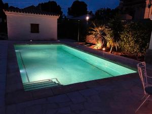 een zwembad in een achtertuin 's nachts bij INNOUTHOME Chalet familiar con piscina privada numero u in L'Ametlla de Mar