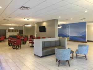 a waiting room with a couch and tables and chairs at Holiday Inn Express - Grand Island by IHG in Niagara Falls